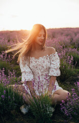 portrait of a young blonde girl in a lavender field in the summer at sunset