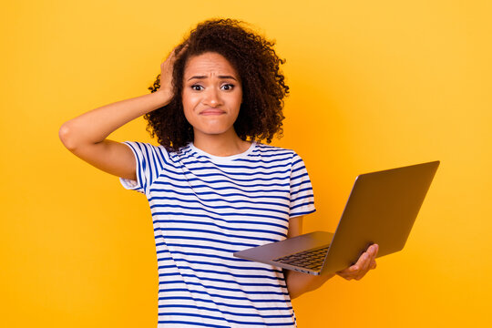 Portrait of unsatisfied lady arm touch head hold netbook isolated on yellow color background