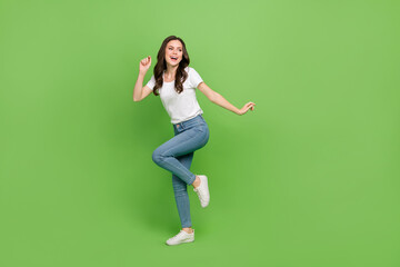 Fototapeta na wymiar Photo of cute charming woman dressed white t-shirt dancing smiling empty space isolated green color background
