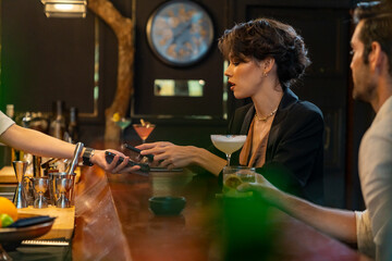 Caucasian woman using mobile banking application on smartphone scan QR code making online payment while hangout party at restaurant bar. Electronic banking and Contactless payment technology concept.