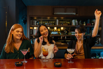 Group of Attractive woman enjoy and fun hangout nightlife meeting and drinking fancy cocktail together at luxury bar. Happy female friends celebrating holiday event party at nightclub in the city