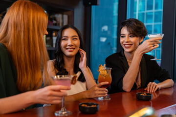 Group of Attractive woman enjoy and fun hangout nightlife meeting and drinking fancy cocktail together at luxury bar. Happy female friends celebrating holiday event party at nightclub in the city