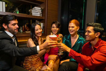 Group of Diversity people celebrating and toasting cocktail glass together at luxury restaurant bar. Happy man and woman friends enjoy and fun holiday hangout party meeting nightlife at nightclub