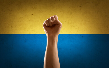 fight, freedom and national concept - hand making fist pump gesture over flag of ukraine on...