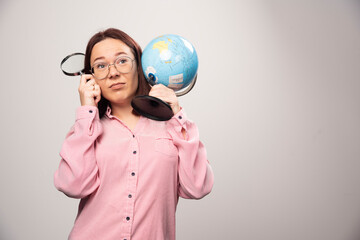 Portrait of woman holding a magnifying glass and Earth globe