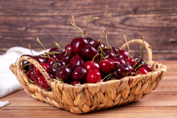 Fresh cherry. Ripe cherries in a basket on wood background. Bulk cherries. close up