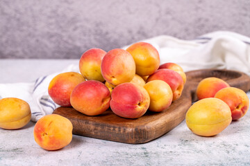 Fresh apricots. Ripe apricots in wooden serving platter on stone background. Bulk apricots. close up