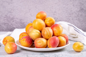 Fresh apricots. Ripe apricots in a plate on a stone background. Bulk apricots. close up