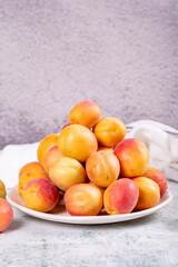 Fresh apricots. Ripe apricots in a plate on a stone background. Bulk apricots. close up