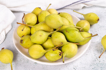 Fresh pear. Ripe pears in plate on stone background. Bulk pear. close up