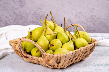 Fresh pear. Ripe pears in a basket on a stone background. Bulk pear. close up
