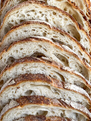 Slices of  fresh bread background. Freshly baked and sliced San Francisco sourdough loaf bread Food background and texture lunch time
