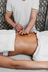 Fototapeta na wymiar Beautiful young woman receiving professional body massage treatment with aromatherapy essential oil.