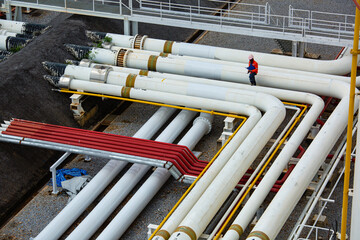 Top view male worker inspection at steel long pipes and pipe elbow in station oil factory during...