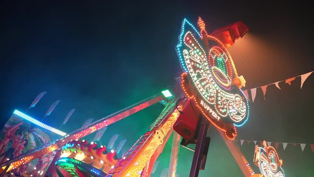 Illuminated Wheel Adrenaline Ride at Amusement Park at Night.
