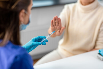 medicine, health and vaccination concept - close up of doctor or nurse with syringe and senior...
