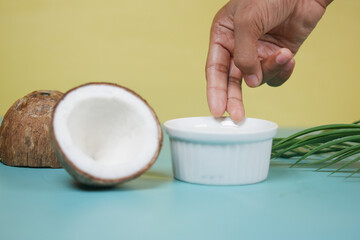 hand pick coconut oil on color background 