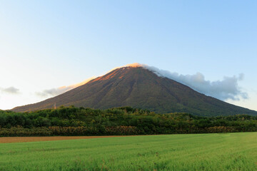 Naklejka premium 秋が訪れた夕日に染まる羊蹄山