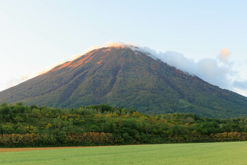 Naklejka premium 秋が訪れた夕日に染まる羊蹄山