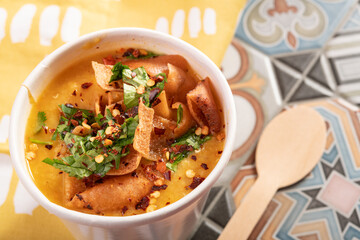 Mediterranean traditional Moroccan lentil soup garnished with flatbread, chilli and coriander