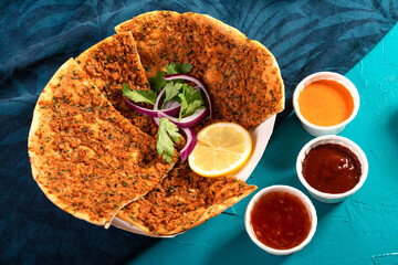 Traditional Moroccan pizza flatbread topped with red lentils and herbs served with dips