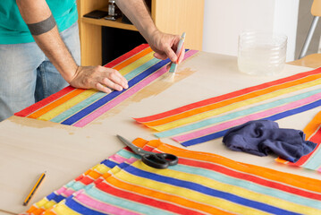 gluing process, adhering colored striped paper man painted on surface. decoration of surfaces for...