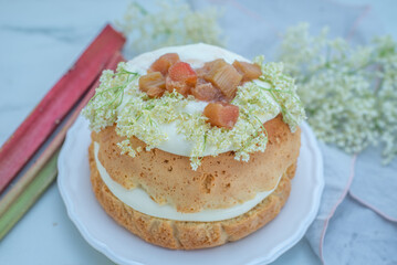 rhubarb vanilla sponge cake with elderflower on a table