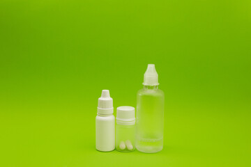 Empty jars, tubes, bottles on a green background