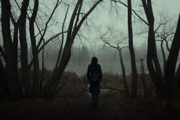 Woman's silhouette in the foggy trees