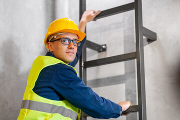 architecture, construction and building concept - male architect in helmet, goggles and safety west climbing ladder or stairs © Syda Productions