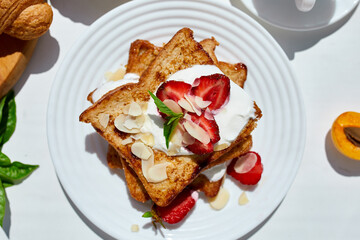 Breakfast of french toast with strawberries and maple syrup, good morning..