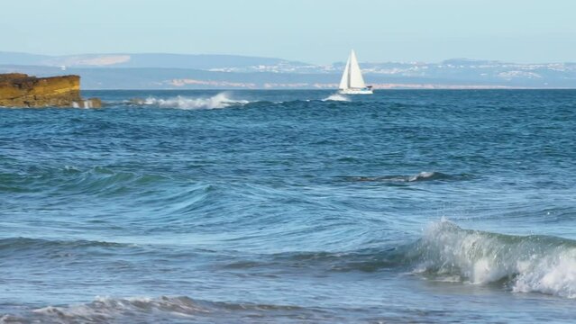 Yacht Sailing On Opened Sea. Sailing Boat. Yacht From beach at a sunny day in Cascais.