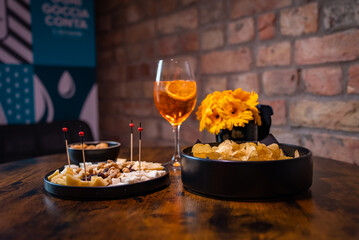 Traditional italian aperitif with cheese, nuts and aperol spritz drink on the wooden table with...