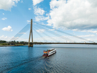 Small cruise ship in Riga, Latvia near the bridge. Small tours down the river Daugava in Riga.