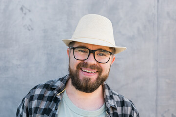 Handsome man tourist portrait looking happy wearing straw hat for travelling, standing against concrete wall background