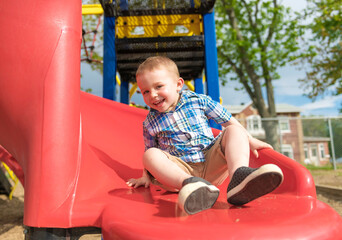 Fototapeta na wymiar Active little boy having fun on playground