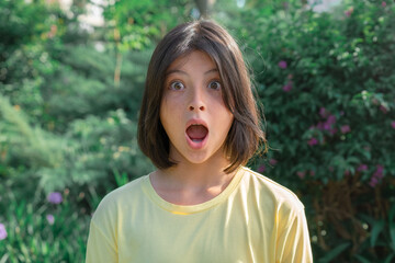 Closeup portrait of a very surprised teenage girl with wide open eyes and mouth.