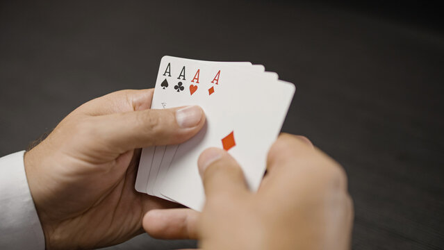 Poker player looking at four of a kind with aces, winning card combination, luck