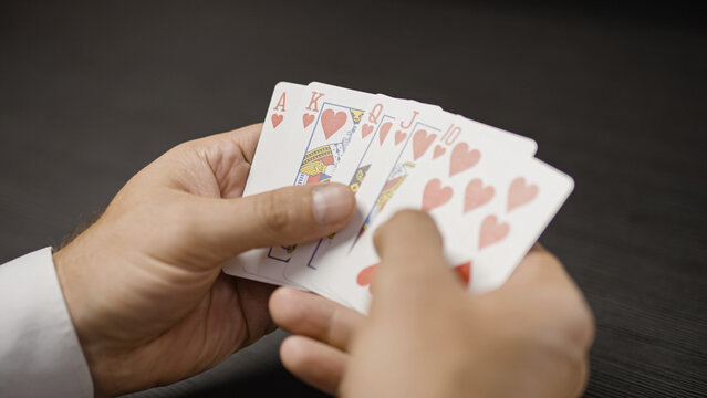 Lucky man showing royal flush card combination while playing poker, success