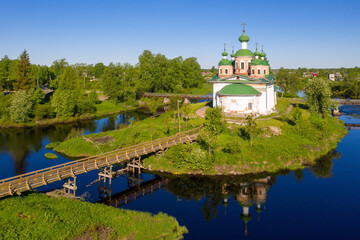 View of Smolensky cathedral and bvridge over Olonka river on sunny summer day. Olonets town, Karelia, Russia.