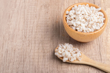 Job's tears boiled in a cup with a wooden spoon. Healthy whole grains.