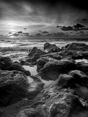 Vertical of rock formations covered with moss on beach of the Baltic Sea in Bornholm in grayscale