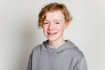 redheaded teen boy with grey shirt on studio