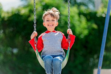 cute five year old boy outside portrait on the playground - obrazy, fototapety, plakaty