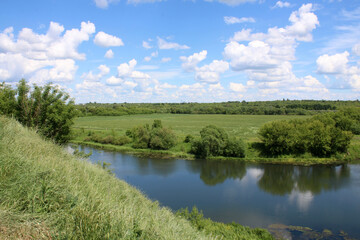 European landscape. High bank of a small calm river.