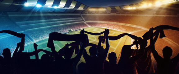 Back view of football, soccer fans cheering their team with scarfs at crowded stadium at evening time. Concept of sport, support, competition. Out of focus effect © master1305