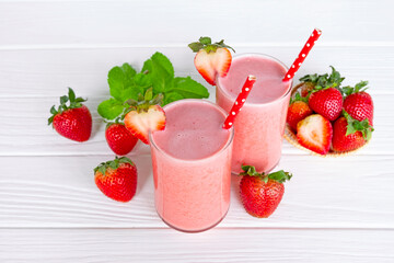 Strawberry yogurt fruit juice smoothie pink colorful fruit juice milkshake blend beverage healthy high protein the taste yummy In glass drink episode morning on white wood background.