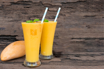 Mango juice fruit smoothies yogurt drink yellow healthy delicious taste in a glass slush for weight loss on wooden background.