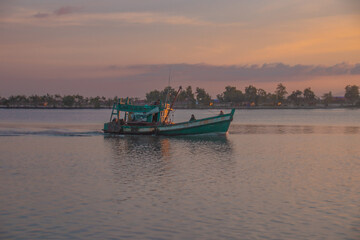 Khmer fishing boat heading out to sea in Kampot Cambodia