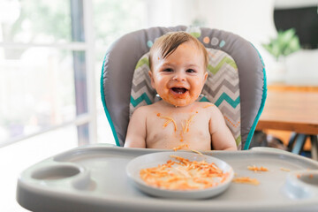 Little baby eating her dinner and making a mess